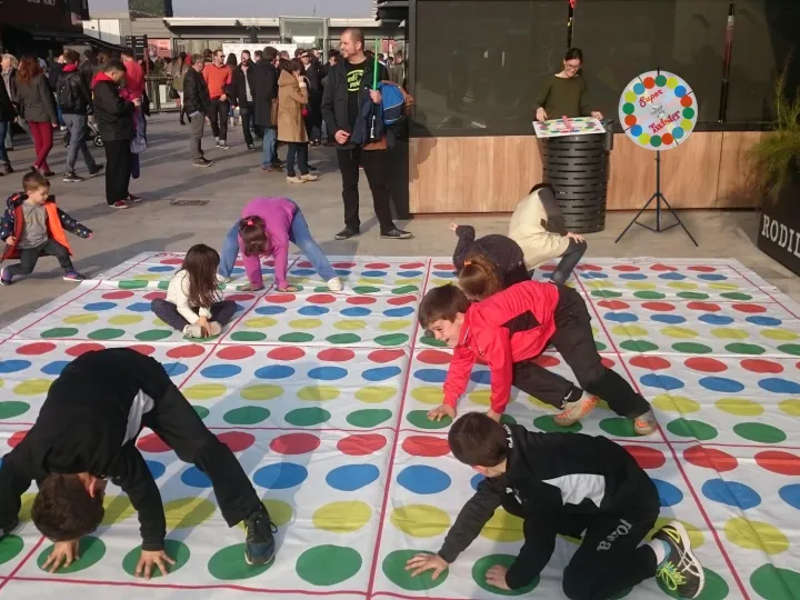 Children playing a giant floor game with a spinner at a shopping centre