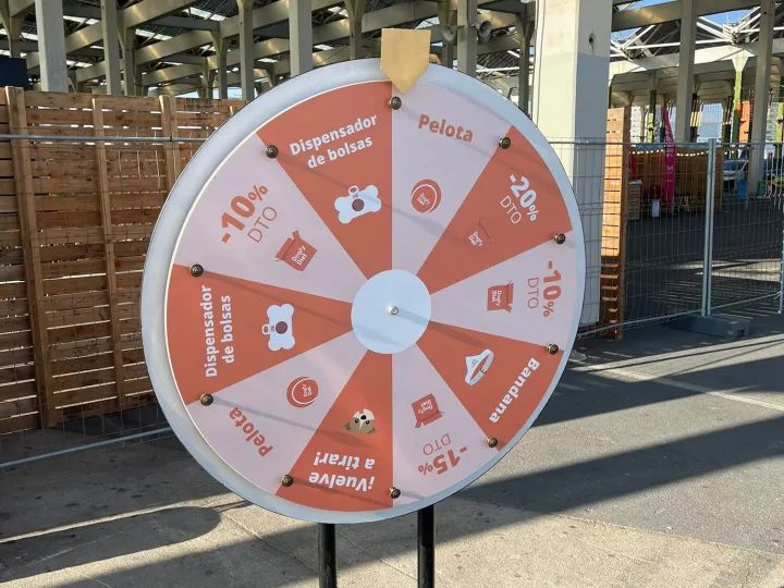 Orange promotional prize wheel with discounts at an outdoor fair