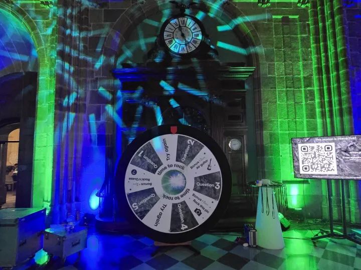 Giant prize wheel at a party with green and blue lights