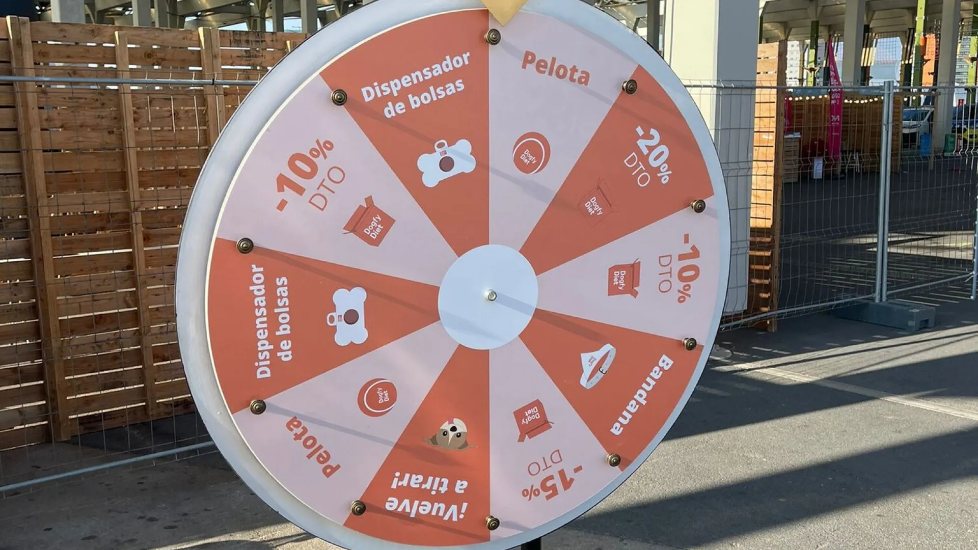 Orange promotional prize wheel with discounts at an outdoor fair
