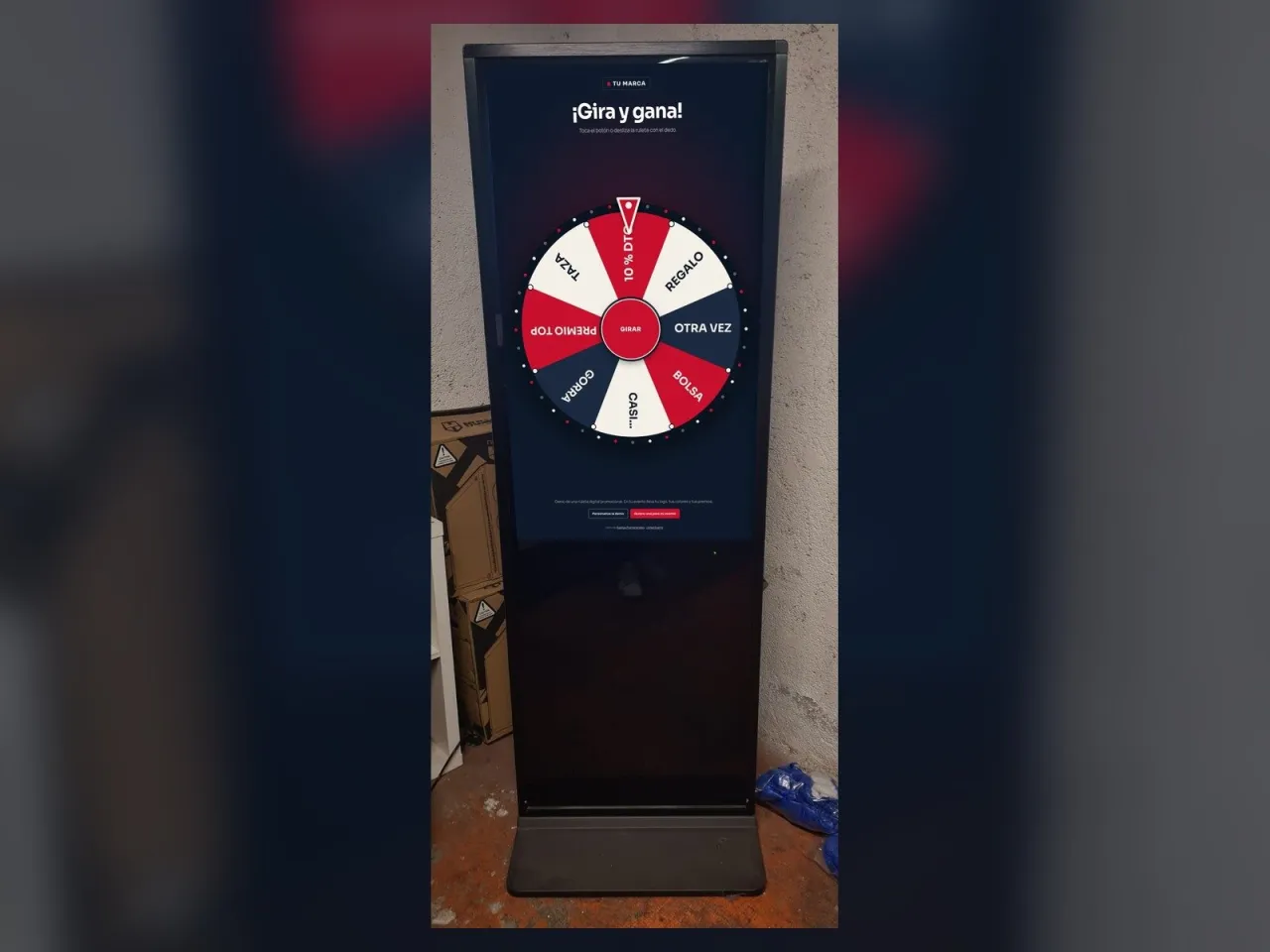 Tótem táctil vertical con una ruleta digital promocional en pantalla
