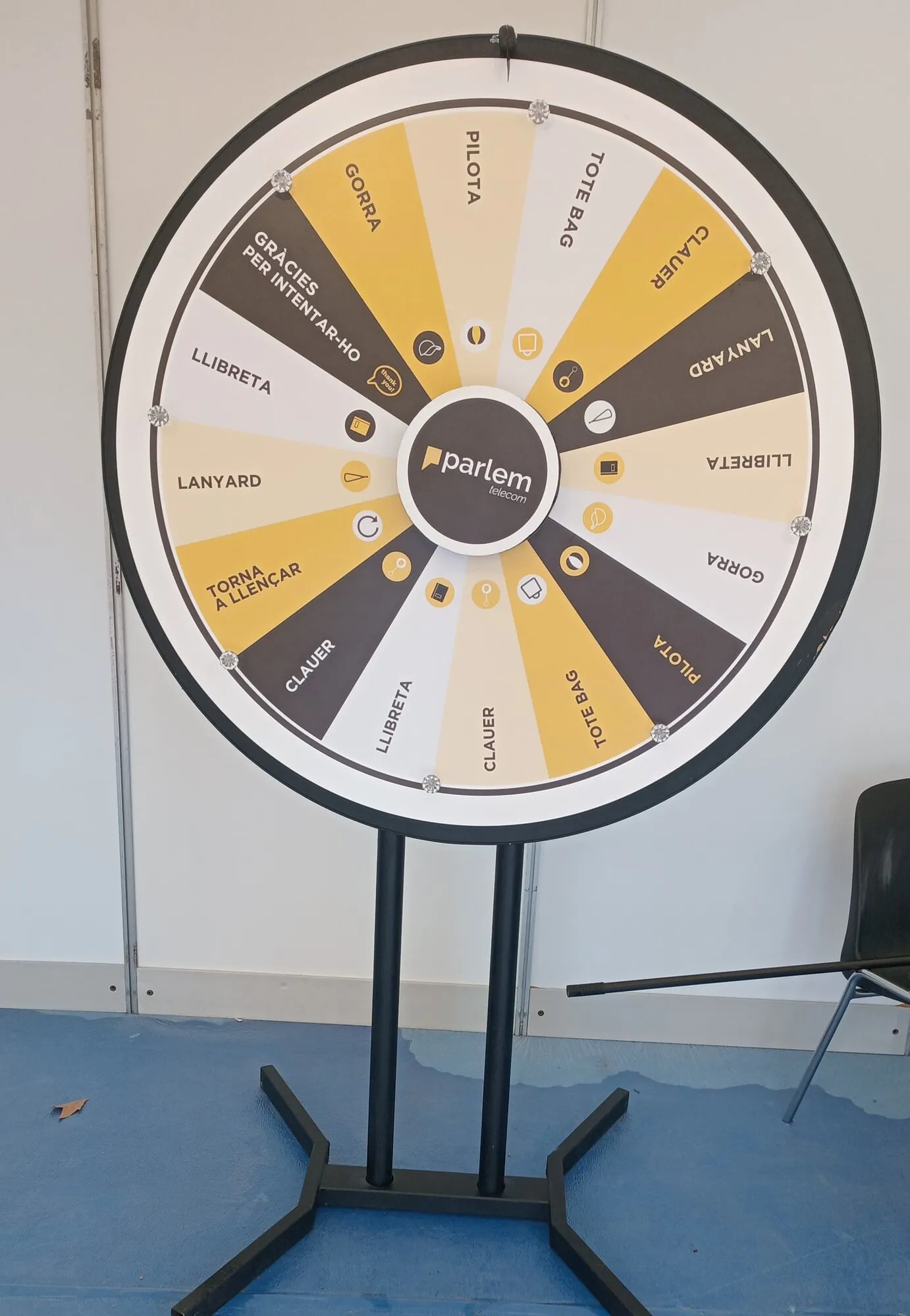 Yellow and grey prize wheel on a white stand