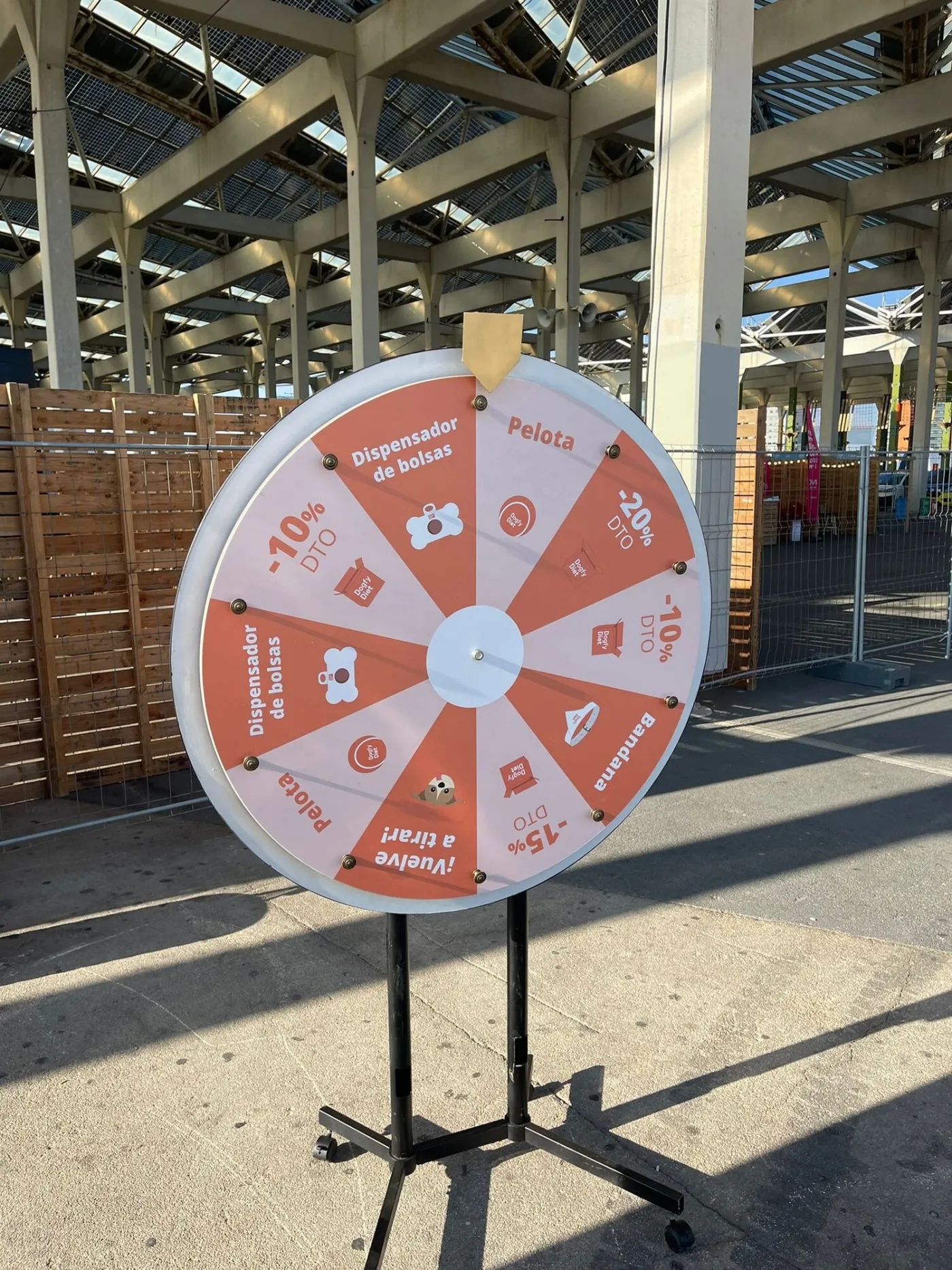 Orange promotional prize wheel with discounts at an outdoor fair