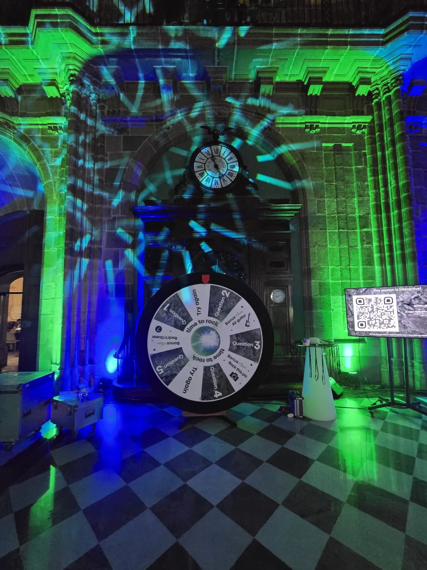 Giant prize wheel at a party with green and blue lights