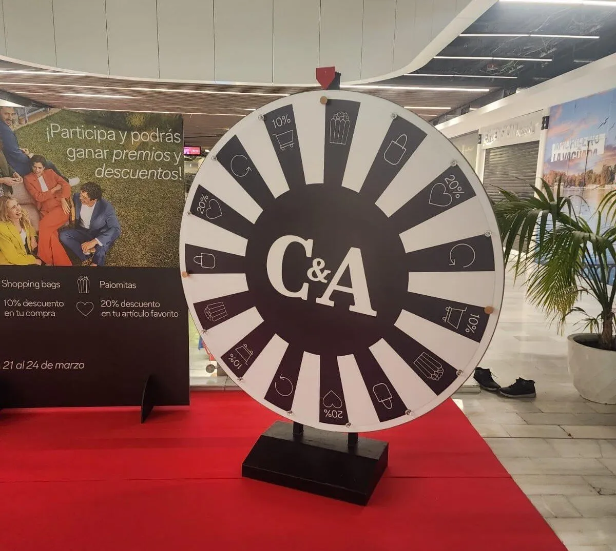Black and white giant wheel on a red carpet in a shopping centre